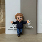 Real product photo of a personalized ChronoFig Little boy 3D figurine created from a photo and displayed on a wooden base.